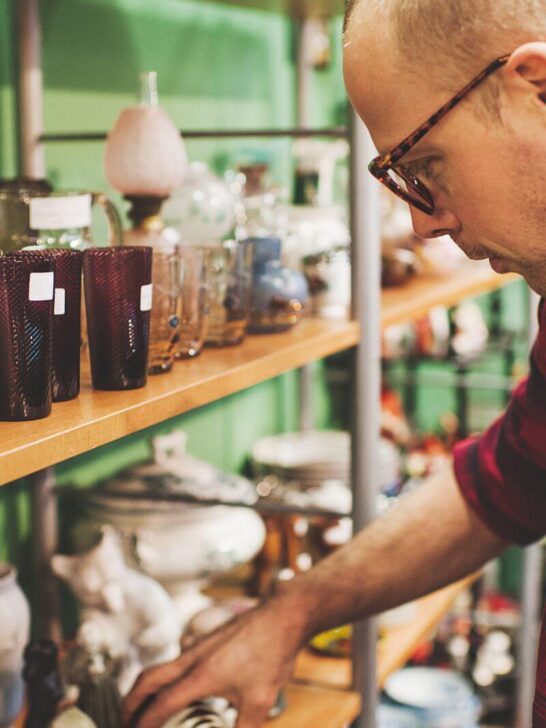 man looking at homewares in charity shop
