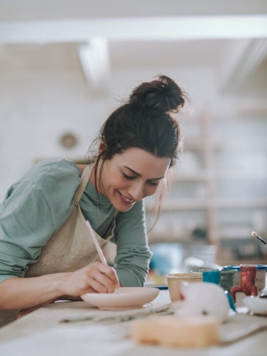 woman painting pottery.