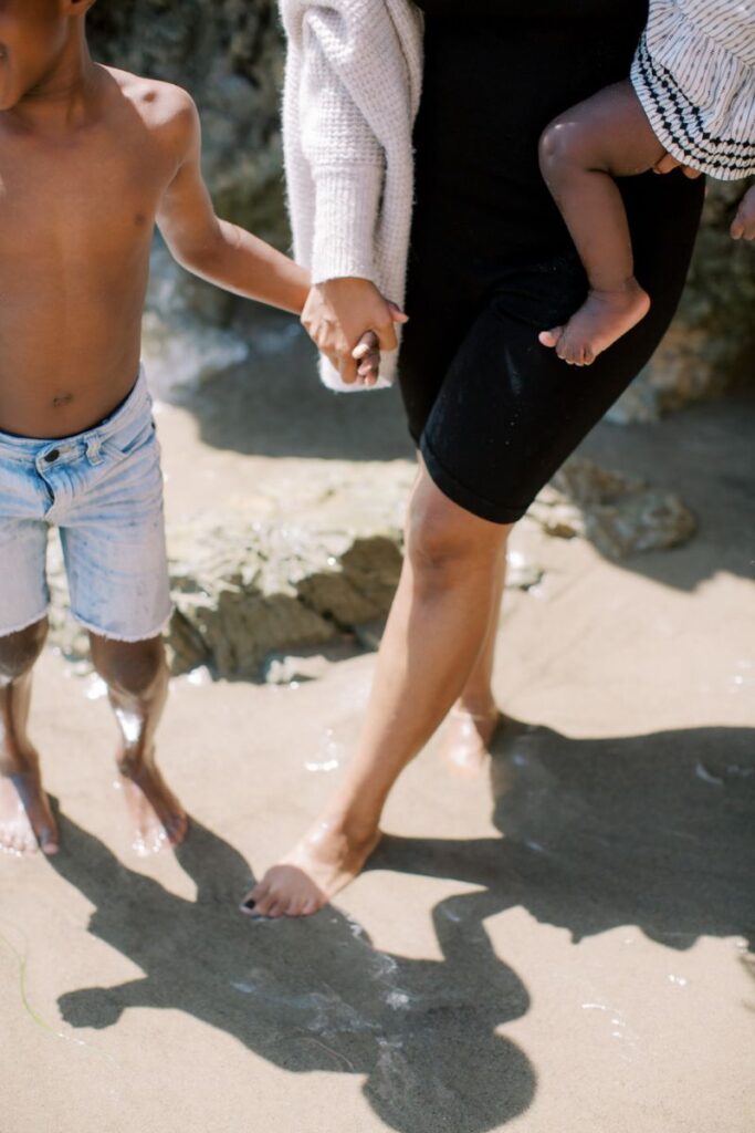 mum, son and baby on beach