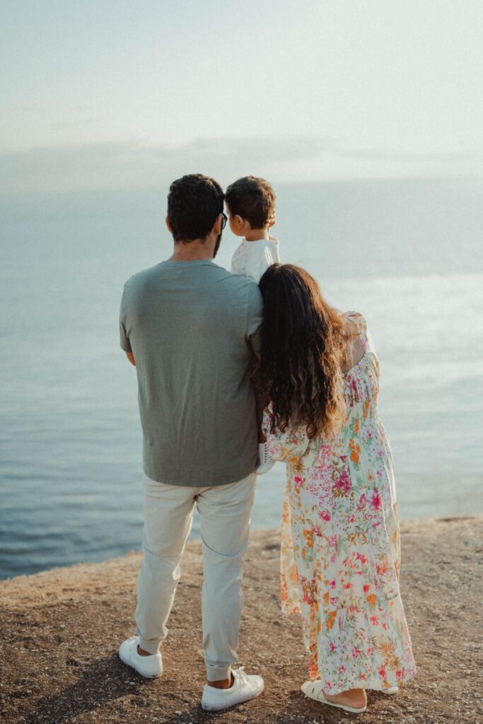 back of family on beach looking at ocean