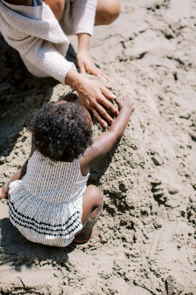 baby making sandcastles with mom